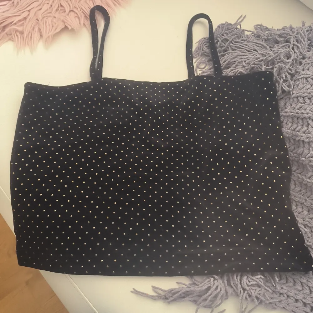 Säljer en svart linnetopp från Bik Bok med små guldprickar. Toppen har smala axelband och är perfekt för en stilren look. Passar bra till både jeans och kjol. Storlek S men passar även M. . Yläosat.