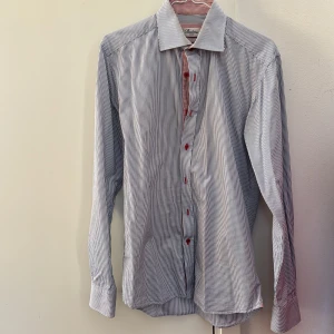 Randig skjorta från Stenströms - Snygg randig skjorta från Stenströms i blått och vitt med röda knappar. Skjortan är slim fit och tillverkad i bomull. Perfekt för en stilren look. Storlek passar både S och M