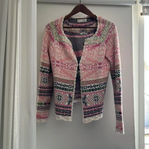 Mönstrad kofta från Odd Molly - Säljer en färgglad och mönstrad kofta från Odd Molly. Koftan har en mix av rosa, grön, vit och svart med ett unikt mönster. Den har långa ärmar och en knytning i ryggen för extra stil. Perfekt för att liva upp garderoben! Storlek M. Köpt för ungefär 1000kr.🩷 Pris kan diskuteras!