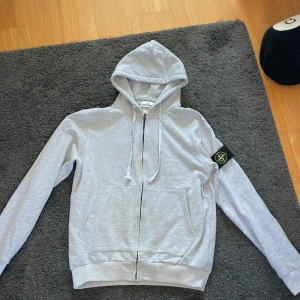 Grå hoodie från Stone Island - Hej säljer en fett stone Island zip up för 900kr men priset kan också diskuteras. Tröjan är ändats använd ett fåtal gånger inomhus och är i nytt skick. Den passar både L och M