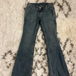 Blå lågmidjade bootcut jeans - Snygga blå bootcut jeans med klassisk femficksdesign och lågmidja.  De har en lätt tvättad look som ger en vintage känsla.