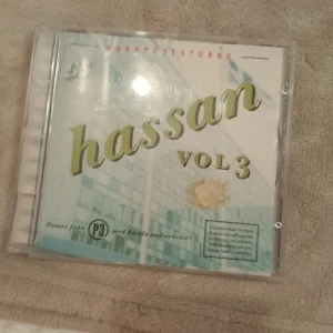 Hassan Vol 3 - CD-skiva med humor från P3:s kända radioprogram Hassan. Innehåller sketcher som 'Elchock', 'Gräsklippare', och 'Bamsegrill'. Perfekt för den som gillar svensk humor och nostalgi.