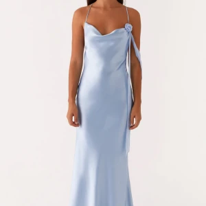 Ljusblå balklänning klänning från Peppermayo - Jag köpte denna eleganta ljusblå klänningen i satin från Peppermayo för att ha på min bal. Den var dock för stor på mig så jag måste tyvärr sälja den eftersom det har gått för lång tid för att skicka tillbaka den. Köpt för 1200kr säljer för 800kr, endast provad med lappar kvar! Klänningen har en vacker rosettdetalj vid axeln och en öppen rygg med korsade band. 