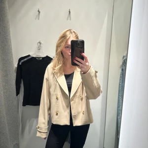 Populär trench coat  - Snygg trench coat med dubbelknäppning. Den har en klassisk krage och långa ärmar. Perfekt för en stilren look. Perfekt till den populära vår trenden. Är en 170 men passar mig som en xs. Aldrig använd 