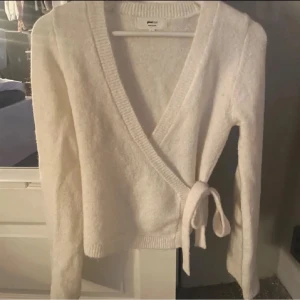 Omlottkofta  - Säljer en mysig vit omlottkofta från Gina Tricot. Knappt använd så i nyskick! 