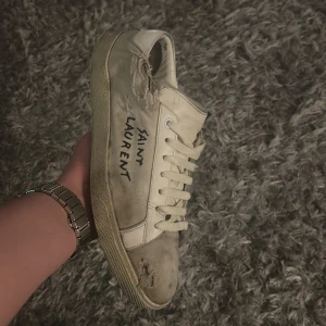 Saint Laurent skor - Ett par riktigt fräna Saint Laurent SL/06 Court i en krämvit färg. Skorna är välanvända med tydliga slitningar men har fortfarande mycket kvar att ge för den som gillar den vintage-inspirerade looken! Endast skorna ingår! 