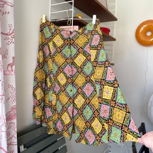 Vintage kjol  - Så fin kjol med knappar, går att välja om man vill ha knapparna framtill eller baktill! Storlek står ej. Uppskattar till strl M! Finns ett litet hål längs en söm samt ser ut att vara sydd på insidan av midjan med egen tråd. I övrigt fint skick!