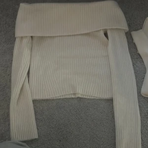 Vit ribbad offshoulder tröja - Säljer en stilren vit ribbad offshoulder tröja. Perfekt för en elegant look med långa ärmar och en mjuk känsla. Passar utmärkt till både jeans och kjol. Hör av dig vid intresse!