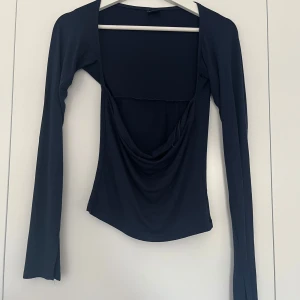 Mörkblå topp från Gina Tricot - Långärmad mörkblå topp från Gina Tricot. Toppen är som en bandeutopp med långa ärmar. Ärmarna har en slits på kanten. I super fint skick, använd max 5 gånger. 100kr