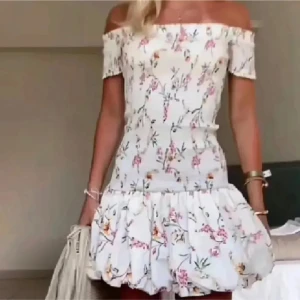 Vit blommig off shoulder klänning - Superfin vit blommig off-shoulder klänning från hm med volang nertill. Lappen med storleken är tyvärr borta men skulle säga att de är M💗skriv för egna bilder!!!