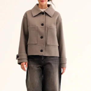 Beige kort jacka med stora fickor - Snygg beige jacka med stora framfickor och stora svarta knappar. Jackan har bred krage, långa ärmar med uppvikta muddar och boxig passform. Perfekt för lager-på-lager och enkel att styla till olika outfits. Nypris 899 men jag säljer för 500 och pris kan diskuteras! 