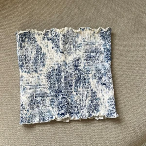 Tubtopp från H&M - Säljer en blåvit tubtopp från H&M med volangkant upptill och nedtill. Haft den länge, men endast använd cirka 3 gånger🤍💙