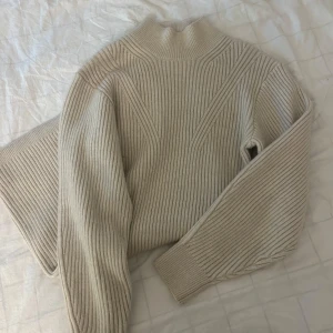Beige ribbstickad långärmad klänning - Säljer en beige ribbstickad klänning med lång ärm. Klänningen har en figurnära passform och är tillverkad i ett mjukt, stickat material som passar perfekt för kyligare dagar.