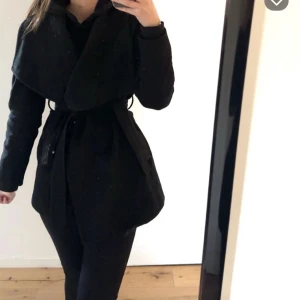 Svart kappa från Mango - Svart kappa från Mango slutar precis ovanför knäna 