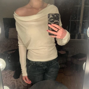 Vit offshoulder tröja - Säljer en stilren vit offshoulder tröja med långa ärmar. Perfekt för en trendig look med en avslappnad passform.