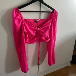 Rosa långärmad topp med knyt - Säljer en snygg rosa topp med knytning framtill från HM divided. Fint skick, storlek M
