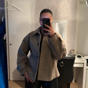 Kort Kappa från Kappahl - Snygg beige kappa från Kappahl med knappar framtill och klassisk krage. Jackan har långa ärmar med uppvikta muddar och en stilren design som passar perfekt för höst och vår. Perfekt för att hålla stilen när det är lite kyligare ute. Är i storlek L men är ganska liten i storlek för att vara en L. Jackan är i relativt bra skick men lite nopprig på framsidan som visas på sista bilden. Pris kan diskuteras 💕🌸