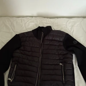 Svart pufferjacka från Moncler - Säljer en svart pufferjacka från Moncler med quiltad framsida och släta ärmar. Jackan har dragkedja framtill och två fickor med dragkedja. Klassisk Moncler-logga på ärmen och innerfoder med märkets etikett.