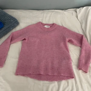 Rosa stickad tröja från Selected Femme - Säljer en mysig rosa stickad tröja från Selected Femme. Tröjan har en rund halsringning och långa ärmar, perfekt för kyligare dagar. Den är enkel och stilren, vilket gör den lätt att matcha med olika outfits. Perfekt för både vardag och avslappnade tillfällen. Jag har knappt använt tröjan. 