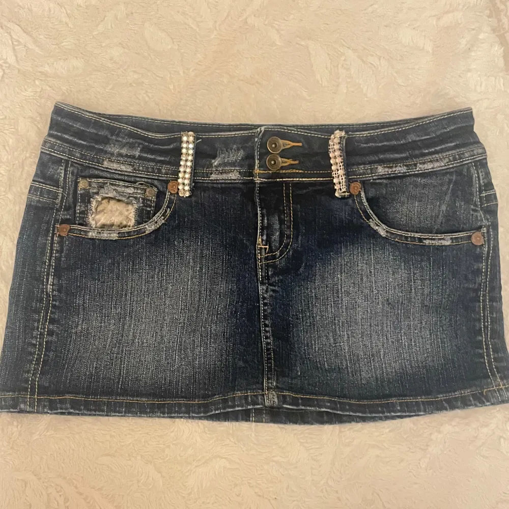 Säljer en mörkblå jeanskjol från Bershka med snygga leopardmönstrade detaljer på bakfickorna och slitning framtill. Kjolen har pärlprydda detaljer vid fickorna och klassisk femficksdesign. Perfekt för dig som gillar en edgy och trendig stil.. Hameet.