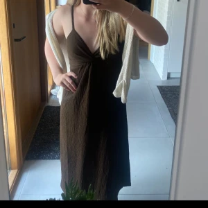 Brun klänning från H&M - Säljer en brun klänning från H&M med smala axelband och twistad detalj framtill. Jättefin till vardags eller fest💞 Inga defekter