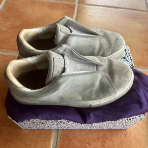 Gråa eytys sneakers - Säljer ett par gråa eytys sneakers i mocka. De är väl använda och har varit inne hos skomakaren vilket man kan se på baksidan där de har försökt fixa, därmed säljer jag de billigt. Låda och dustbag kommer med! Hör av er om ni har fler frågor 💞