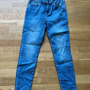 Blå skinny jeans med hög midja - Snygga blå skinny jeans med hög midja och klassisk femficksdesign. Jeansen har en smal passform hela vägen ner och är tillverkade i stretchigt denim.