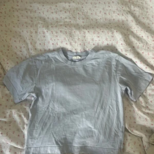 Ljusblå t-shirt från Gina Tricot - Enkel och stilren ljusblå t-shirt från Gina Tricot. T-shirten har rund halsringning och korta ärmar. Perfekt för en clean och avslappnad look nu till sommaren!