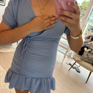 Ljusblå klänning med volang - Säljer en Supersöt ljusblå kortklänning med v-rigning och knyt i midjan !! 💛💛 I storleken xxs. Andvänt ett fåtal par gånger! 💓