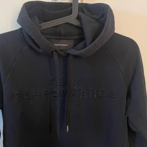 Svart hoddie  - Svart hoddie från peakperformance, storlek S. 