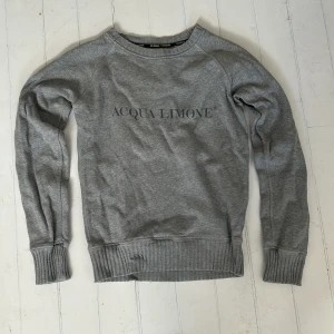 Grå sweatshirt från Acqua Limone - Säljer nu en Acqua Limone tröja i bra skick! Tröjan är några år gammal och därför har förlorat lite färg på trycket (se bild).