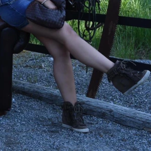 Bruna mockasneakers med fransar och kilklack - Säljer ett par bruna sneakers i mocka med coola fransdetaljer och snörning framtill. Skorna har en dold kilklack. Väl använda. 