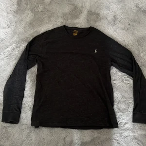 Svart tröja Polo Ralph Lauren - Svart långärmad tröja från Polo Ralph Lauren i slim fit-modell. Original storlek L men sitter som en M