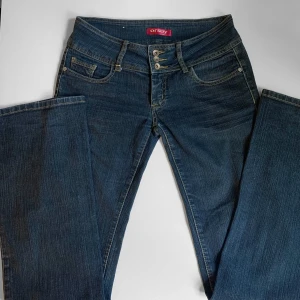 Lågmidjade jeans  - Mörkblå bootcutjeans från Orsay med låg midja och tre gylfknappar. Meddelanför fler bilder eller mått :) Proset kan diskuteras
