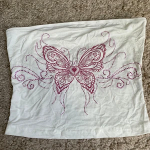 Vit tubtopp med rosa fjärilstryck - Säljer en vit tubtopp med ett stort, detaljerat rosa fjärilstryck framtill💗Pris går att diskutera💗