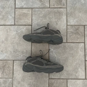 Adidas Yeezy 500 i mörkgrå mocka - Säljer ett par Adidas Yeezy 500 sneakers i mörkgrå färg. Skorna har chunky sula, meshpaneler och detaljer i mocka för en riktigt modern vibe. Perfekta för dig som gillar streetwear och vill sticka ut med en stilren och clean look. Pris går självklart att diskuteras