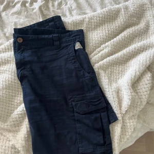 Mörkblå shorts med fickor - Snygga mörkblå shorts med flera praktiska fickor på sidorna 