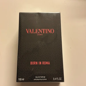 Valentino Uomo Born In Roma EdP 100ml - Parfymen Valentino Uomo Born In Roma Eau de Parfum kommer i en snygg svart kartong med diskret mönster och röd text. Flaskan rymmer 100 ml och är en lyxig doft för den som vill sticka ut med en modern och elegant stil. Helt ny och oöppnad 