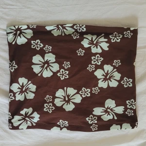 Somrig tubtopp - En blommig tubtopp från hm i storlek xs. Den är ganska kort ungefär navel längd. Säljer pga den inte används 