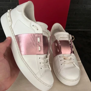 Valentino Garavani Open sneakers vit/rosa - Super snygga och söta valentino open skorna i otroligt bra skick nästan som nya. Storlek 38, allt som du ser på bild tillkommer box extra snören skopåse Valentino kort. Självklart äkta 