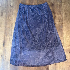 Mörkbrun blommig långkjol - Säljer en mellan lång kjol. Kjolen är brunare i verkligheten än på bilden. 