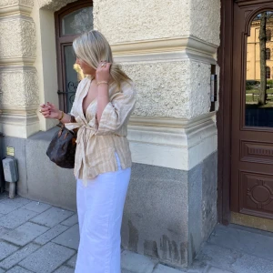 Blus  - Söt randig blus med ett knyte i mitten vilket gör att den passar flera storlekar då man kan dra åt den hur man vill att den ska sitta! 