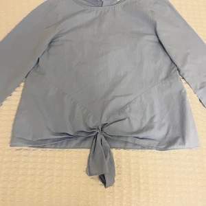 Ljusblå blus med en knytning från zara  - Supersöt ljusblå blus med en knytning på framsidan. Storlek 152 och varan är i ett mycket bra skick.