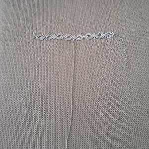 Silverfärgat glittrigt halsband - Snyggt halsband i silverfärg med glittrande detaljer. Halsbandet har ett flätat mönster med små stenar som ger extra bling. Justerbar kedja för perfekt passform. Perfekt accessoar för att lyfta din outfit.