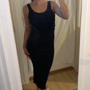 Svart ärmlös klänning - Snygg svart ärmlös klänning med en tight passform från H&M. Strlk S. Säljer då den inte kommer till användning. 