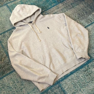 Grå Polo Ralph Lauren hoodie - Tjena! Nu finns denna tvär feta Gråa Polo Ralph Lauren Hoodien till salu. Den är i toppen skick! Utan några skador 🙌Strkl L och självklart 100% äkta! MVH Abbe 