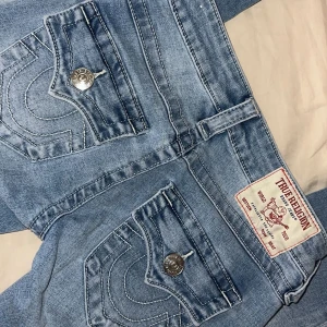 Blå jeans från True Religion - Snygga blå jeans från True Religion i modellen JOEY Low Rise Flare i storlek 23. Har sytt upp dom hos en skräddare då som va för långa för mig så skulle säga att dom passar någon som är 150-153cm lång. Använt fåtal gånger (pris kan diskuteras)🤗