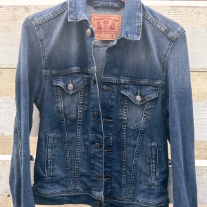 Snygg jeansjacka från Grant! - Snygg jeansjacka med fickor fram och knappar i storlek S från Grant (American Classic Jeans). Köpt på herravdelningen men är lätt figursydd och stretchig så Unisexmodell. Storlek S är herrstorlek. Oanvänd.