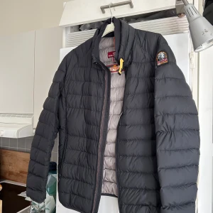 Svart pufferjacka från Parajumpers - Säljer en stilren svart pufferjacka från Parajumpers. Jackan har en dragkedja framtill och en broderad logga på ärmen. Perfekt inför vår.   Skicket är helt okej. 
