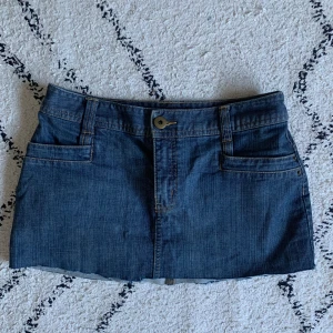 Jeans minikjol - Kort jeanskjol köpt second hand, märket är lite äldre h&m. Storlek 38 men passar även S beroende på hur man vill att den ska sitta.                                           Midja: 39  Längd: 28 ifram ca 30 ibak (går att klippa ännu lite kortare om man vill)
